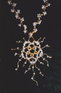 Collier avec un grand pendentif en forme de soleil entièrement monté avec des perles de rocaille, de cristal de roche et citrines