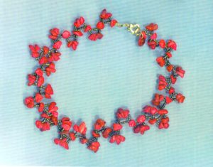 Tour de cou avec enfilage de perles forme baroque d'agate teintée rouge, et perles de rocaille comme une couronne de fleurs