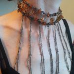 Tour de cou en plastron avec enfilage de perles de rocaille, perles de bois, ambre et pierres fines mauves et ses pendants longs et fins de perles de rocailles et petites ayolites mauves