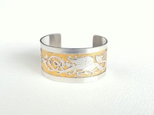 Création bracelet manchette pièce unique en laiton avec motif de dragon argenté en relief tout autour, et le fond ciselé et doré