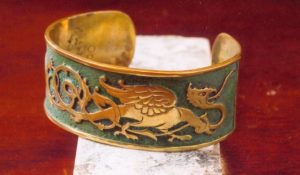 Création bracelet manchette pièce unique en laiton avec motif de dragon en relief tout autour, et le fond ciselé et patiné vert