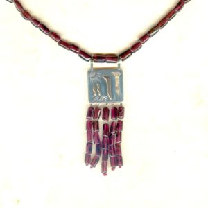 Création pièce unique d'un pendentif argent et or avec motif abstrait, monté avec perles tubes de grenats