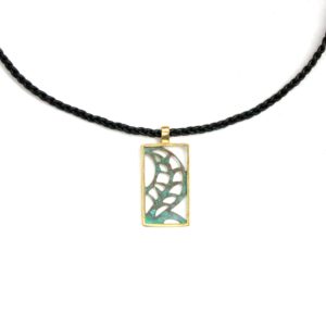Création pendentif rectangle en laiton avec motif de feuille stylisée ajourée et patinée vert, l'encadrement doré, monté sur tour une tresse de cuir fine noire.