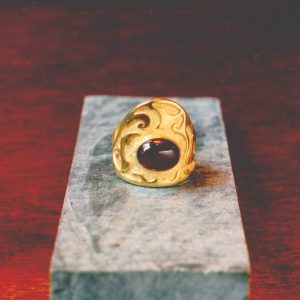 Bague pièce unique en laiton doré à l'or fin, large avec motifs organiques en creux et gros cabochon ovale de grenat