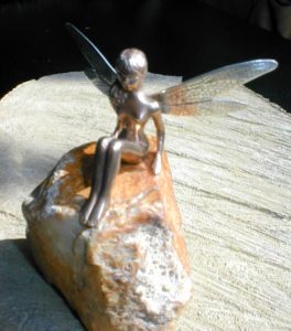 Petite fée en bronze de 3,2 cm, assise sur un caillou comme un rocher, aux ailes de libellule en argent gravées au burin