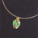Gouaché réaliste d'un projet de bijou collier pendentif doré d'un scarabée stylisé sur fond noir
