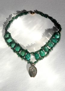 Collier pendentif scarabée stylisé en laiton et patine vert de gris, monté sur un tour de cou avec grosses turquoises véritables et petites agates mousse