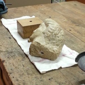 Soclage en cours d'une tête en marbre d'Aphrodisias datant du IVé siècle sur son socle en chêne massif