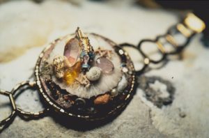 Barecelet comme une montre avec un disque de bois sur lequel sont dsiposés un petit poison cloisonné émaillé, coquillages et c gorgones, comme sur un fond des mers