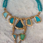 Collier plastron avec tessons de verre couleur bleus et verts cerclés de résine dorée et montés avec perles de bois et verre