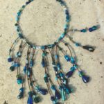 collier tour de cou et plastron avec grands pendants de perles de verres aux différentes formes dans les tons bleus et verts