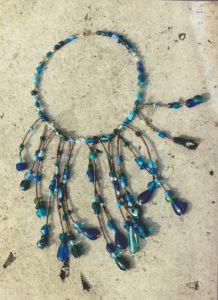 collier tour de cou et plastron avec grands pendants de perles de verres aux différentes formes dans les tons bleus et verts