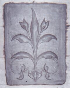 Bas relief modelé en terre représentant des fleurs