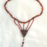 Collier ras de cou petit plastron perles en bois et grenats avec son pendentif triangle pointe en bas en bois de wenge, clou doré apparaissant, et breloque de gouttes de grenats finissant