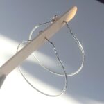 Créoles en argent fermées avec de la chaîne sur l'attache d'oreille