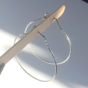 Créoles en argent fermées avec de la chaîne sur l'attache d'oreille