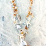 Sautoir de Siréne avec corail, ambre, citrines, coquillages, galet, crayon d'oursin serti résine, agates, étoile de mer sertie résine, bois, perle de terre, graine de rudrakcha, perles de rocaille argent, montés sur cordon de soie