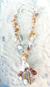Sautoir de Siréne avec corail, ambre, citrines, coquillages, galet, crayon d'oursin serti résine, agates, étoile de mer sertie résine, bois, perle de terre, graine de rudrakcha, perles de rocaille argent, montés sur cordon de soie